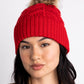 Loopy Cable Pom Hat in color Ruby Red on a model